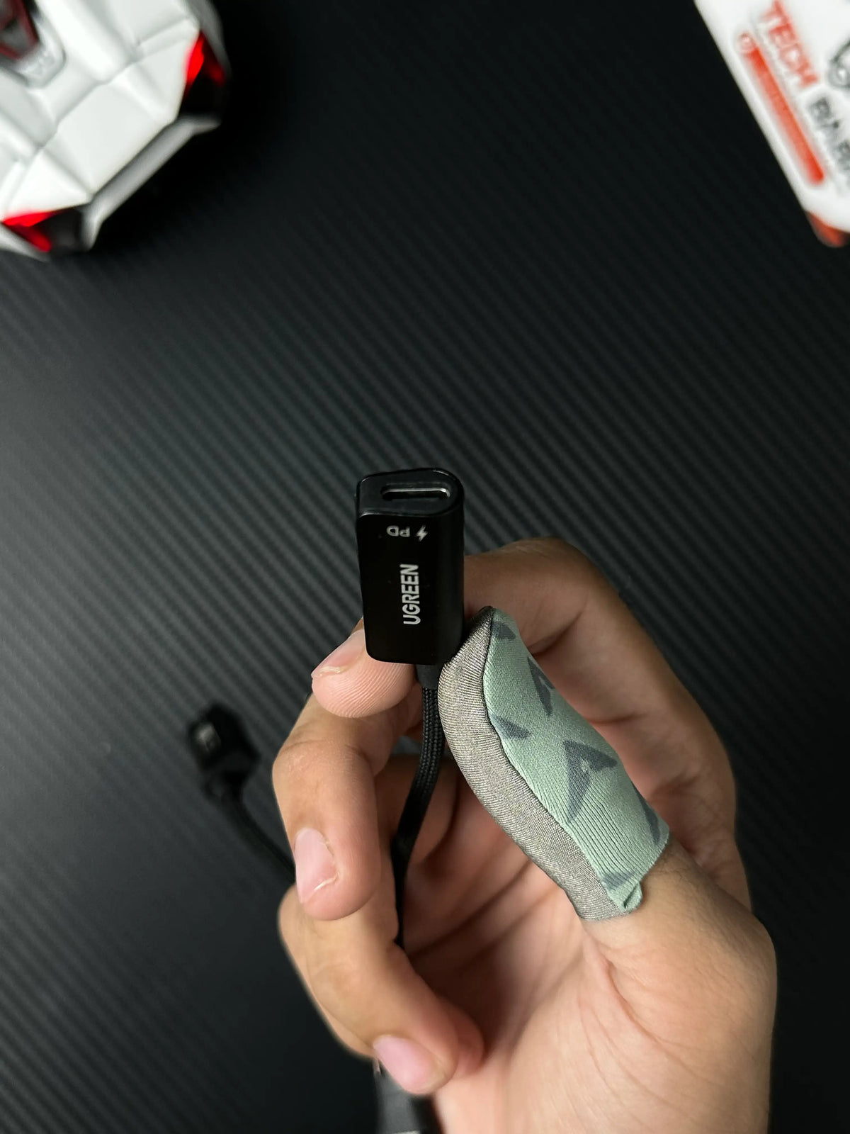 A hand holding UGREEN 25837 USB-C to 3.5mm Audio Adapter Pakistan which has showing 3.5mm charging connector .picture by TechBabaStore.pk