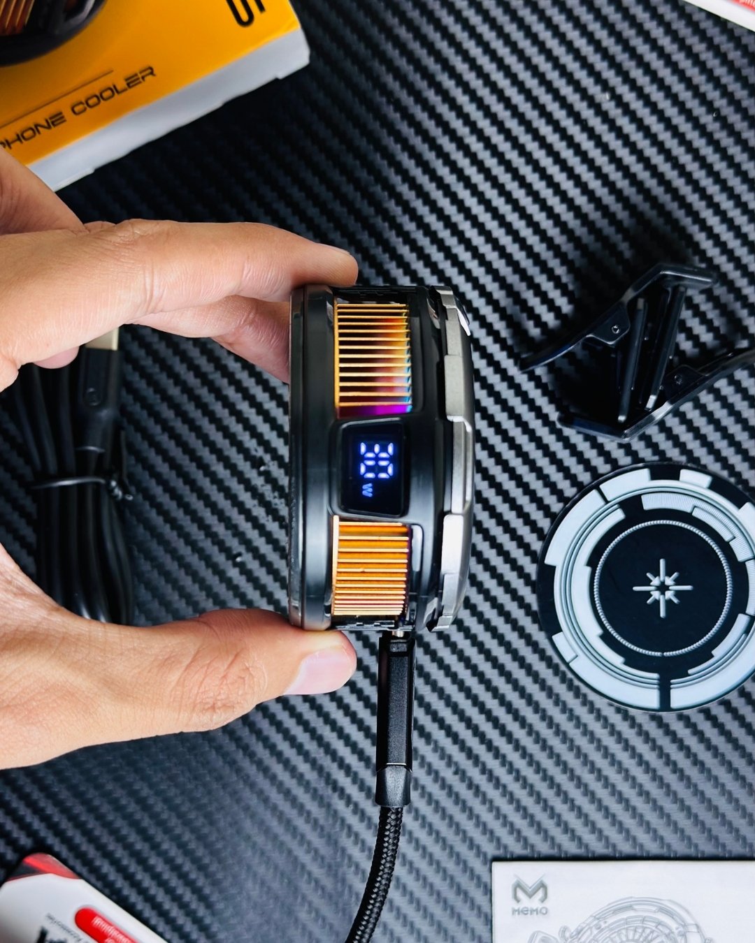 a hand holding a MEMO_CX26_Ultra_30W_Phone_Cooler and showing a side display closeup view. picture by techbabastore.pk