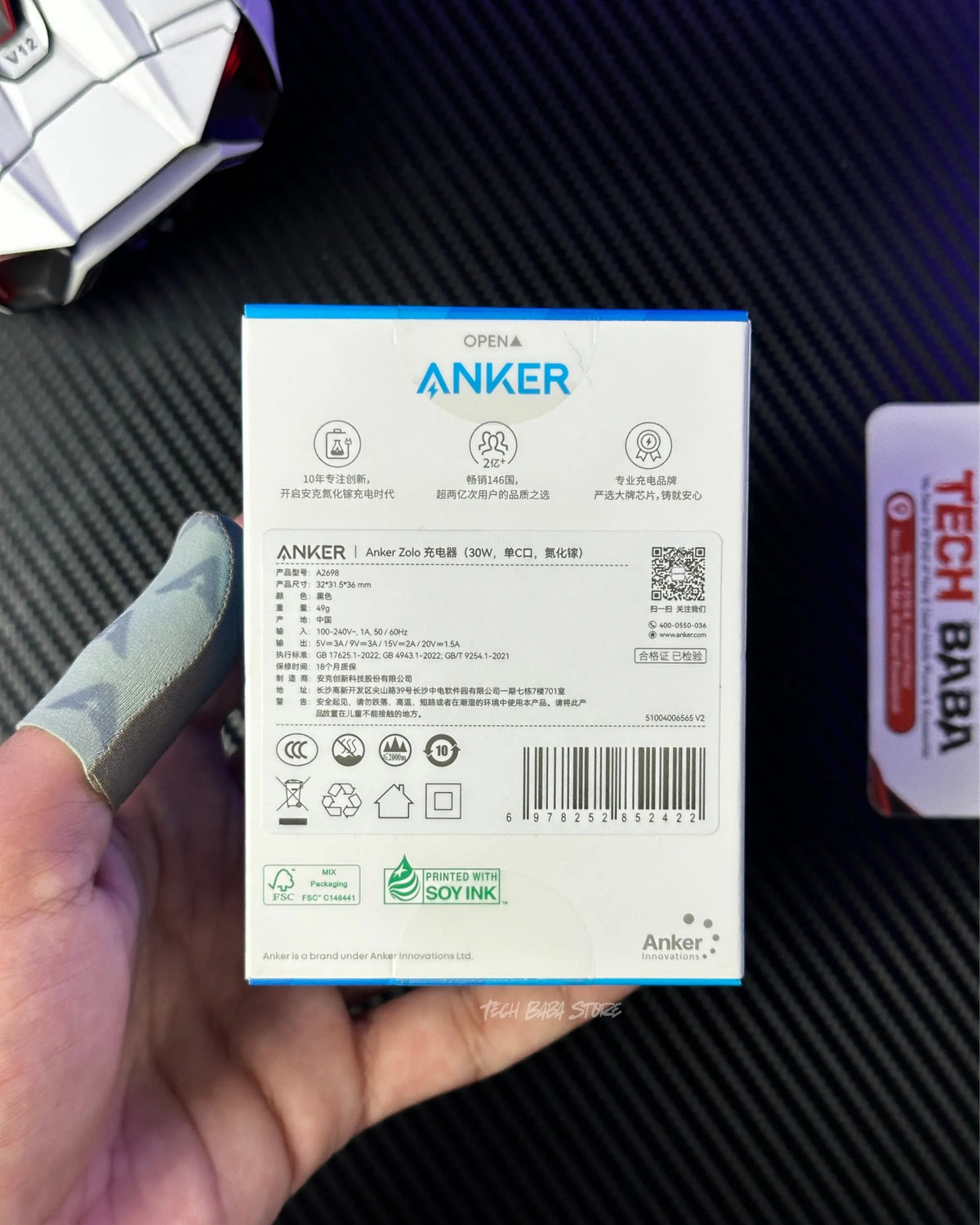 a hand holding a box of  Anker Zolo 30W Compact USB-C GaN Charger and showing back side of this box. picture by techbabastore.pk