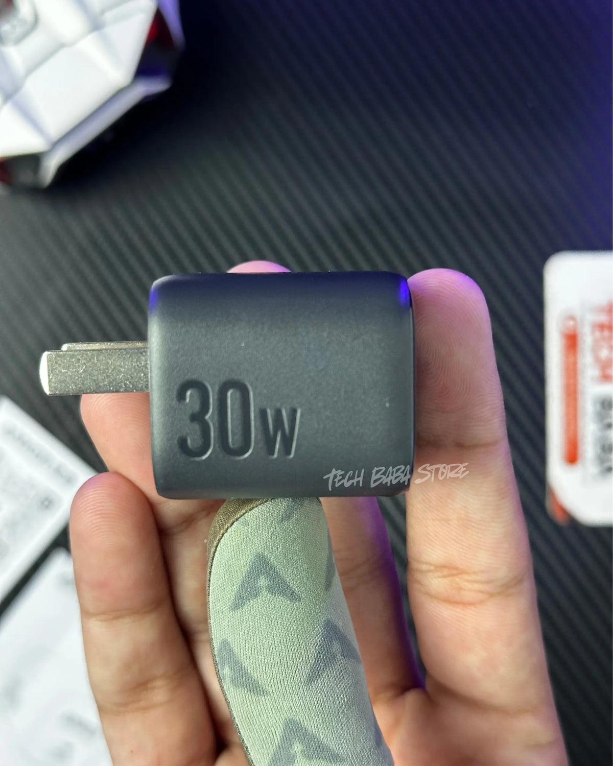 a hand holding a  Anker Zolo 30W Compact USB-C GaN Charger that showing the charging speed and showing the closeup view. picture by techbabastore.pk