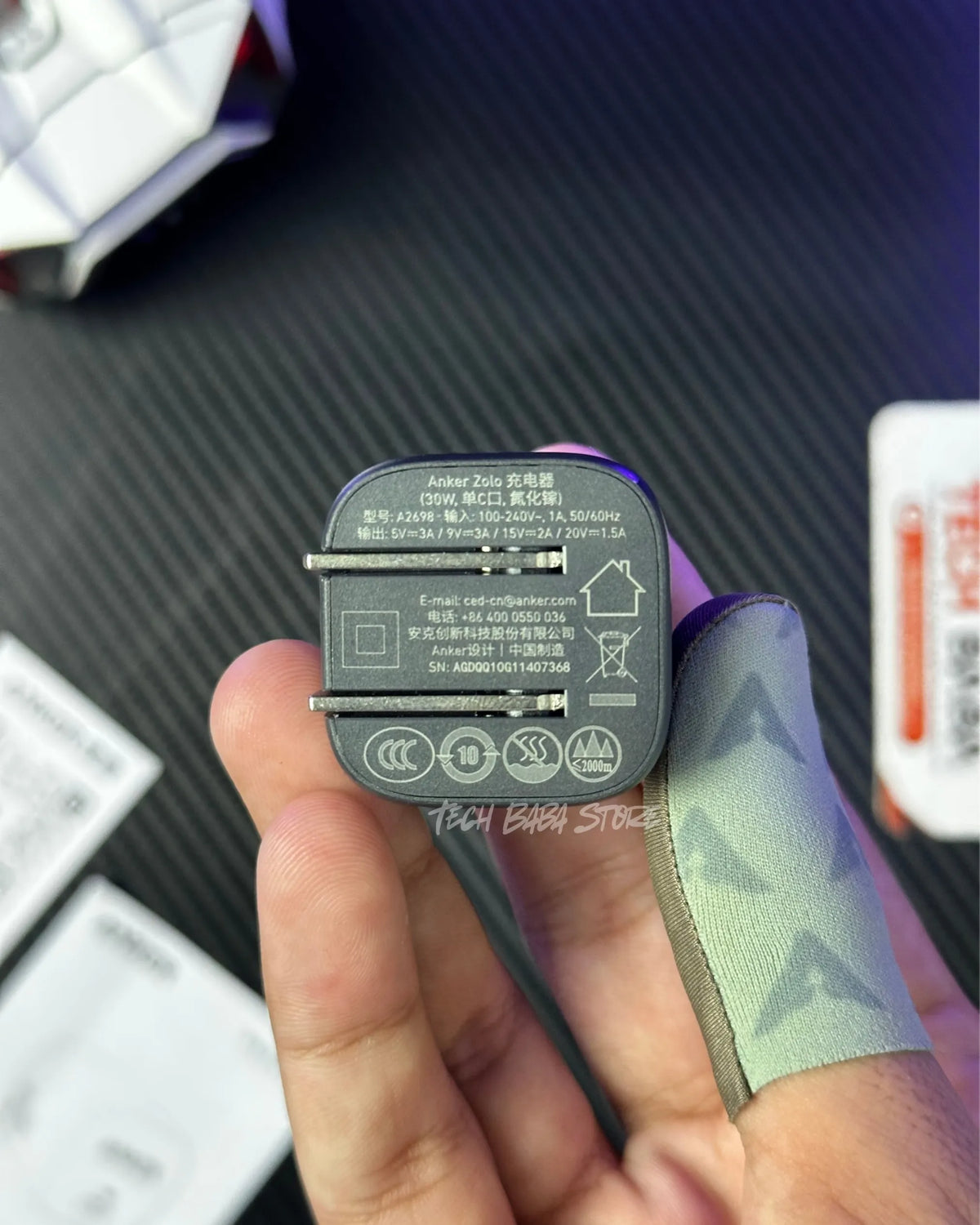 a hand holding a  Anker Zolo 30W Compact USB-C GaN Charger and showing the technical specification. picture by techbabastore.pk