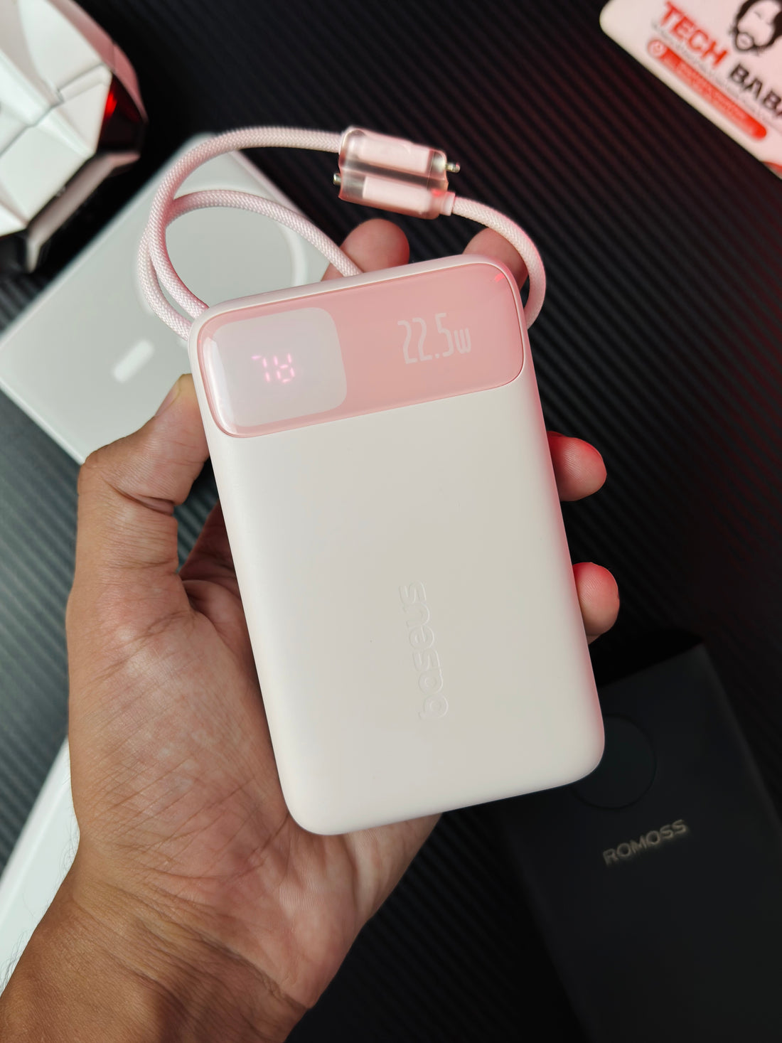 A handi holding a Pink colour Baseus Enerfill FC11 20000mAh 22.5W Power Bank that comes in packing. Picture by Techbabastore.pk