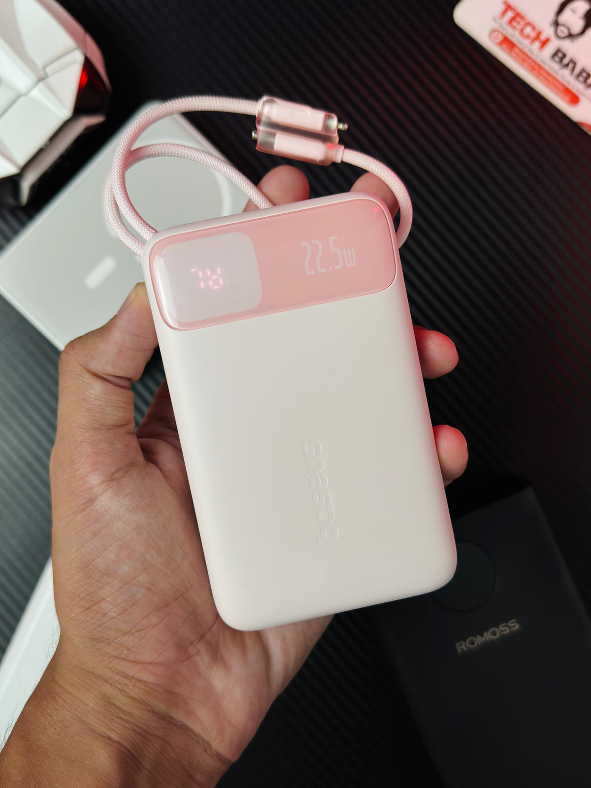 A handi holding a Pink colour Baseus Enerfill FC11 20000mAh 22.5W Power Bank that comes in packing. Picture by Techbabastore.pk