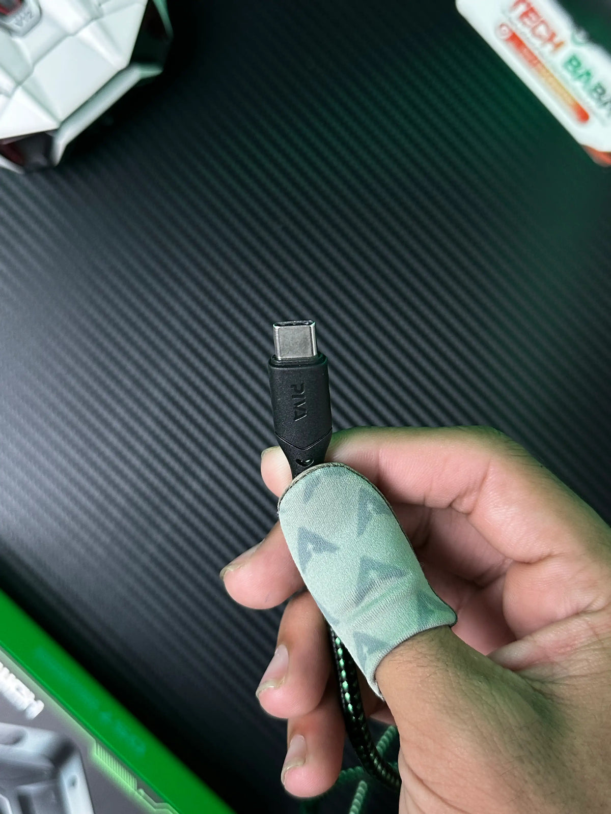 A hand holing Piva DS7 7-in-1 Gaming Splitter — Ethernet, 100W PD, 4K HDMI for PUBG Mobile which has showing closeup shot of Piva DS7 7-in-1 Gaming Splitter — Ethernet, 100W PD, 4K HDMI for PUBG Mobile Ctype cable.picture by TechBabaStore.pk