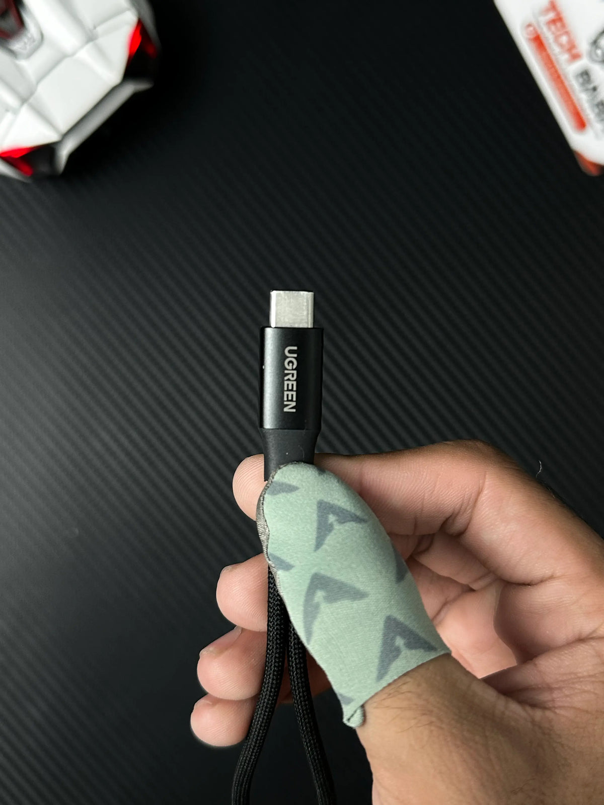 A hand holding UGREEN 25837 USB-C to 3.5mm Audio Adapter Pakistan which has showing Ctype.picture byTechBabaStore.pk