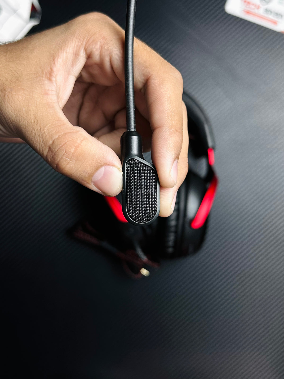 A hand holding  HyperX Cloud III Gaming Headset for PUBG Mobile — Zero-Delay Wired Audio, 53mm Drivers, Detachable Mic | Best Price in Pakistan which has showing Detachable Mic.picture by TechBabaStore.pk