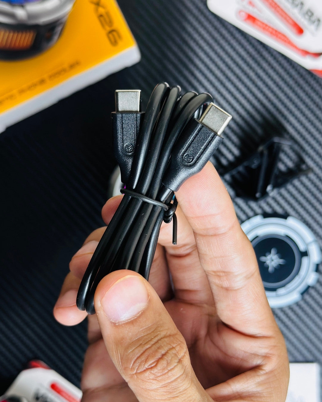 a hand holding a charging cable that comes to MEMO_CX26_Ultra_30W_Phone_Cooler. picture by techbabastore.pk