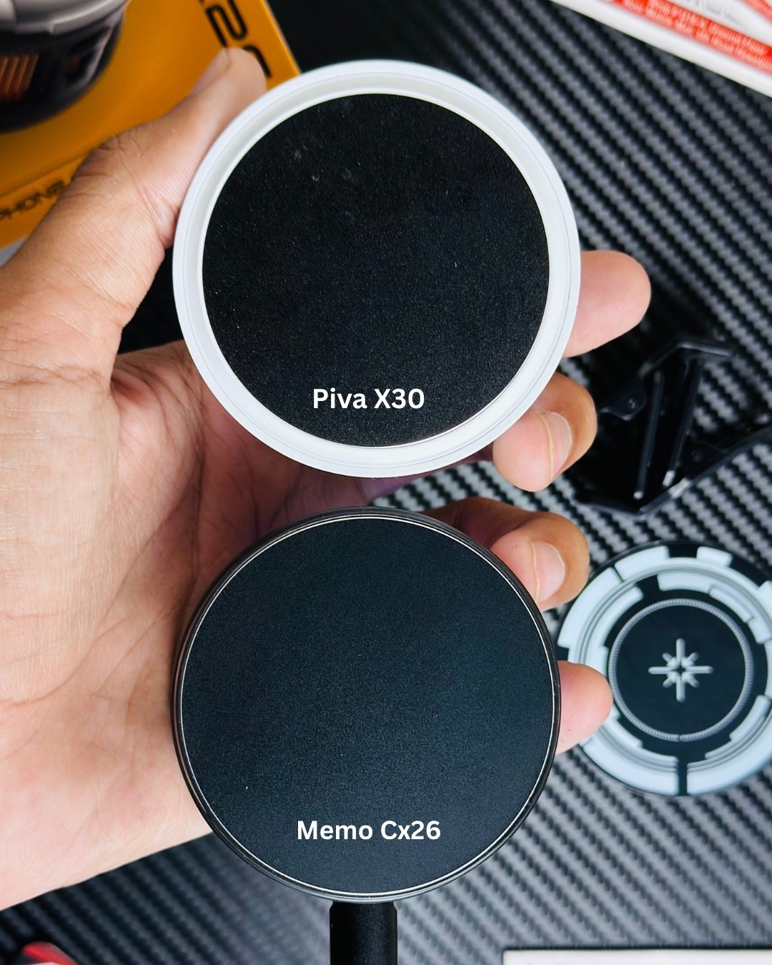 a hand holding a MEMO_CX26_Ultra_30W_Phone_Cooler and showing diffrence between pivax30 and memoCx26. picture by techbabastore.pk