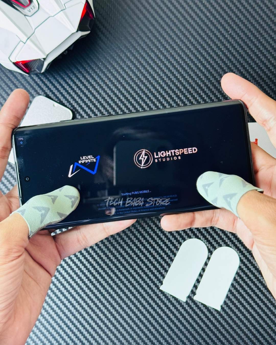 Showing both hands holding a phone in which pubg is playing and both hands are wearing Piva DragonScale 2 ThumbSleeves in both hand's thumb. Picture by TechBabaStore.pk