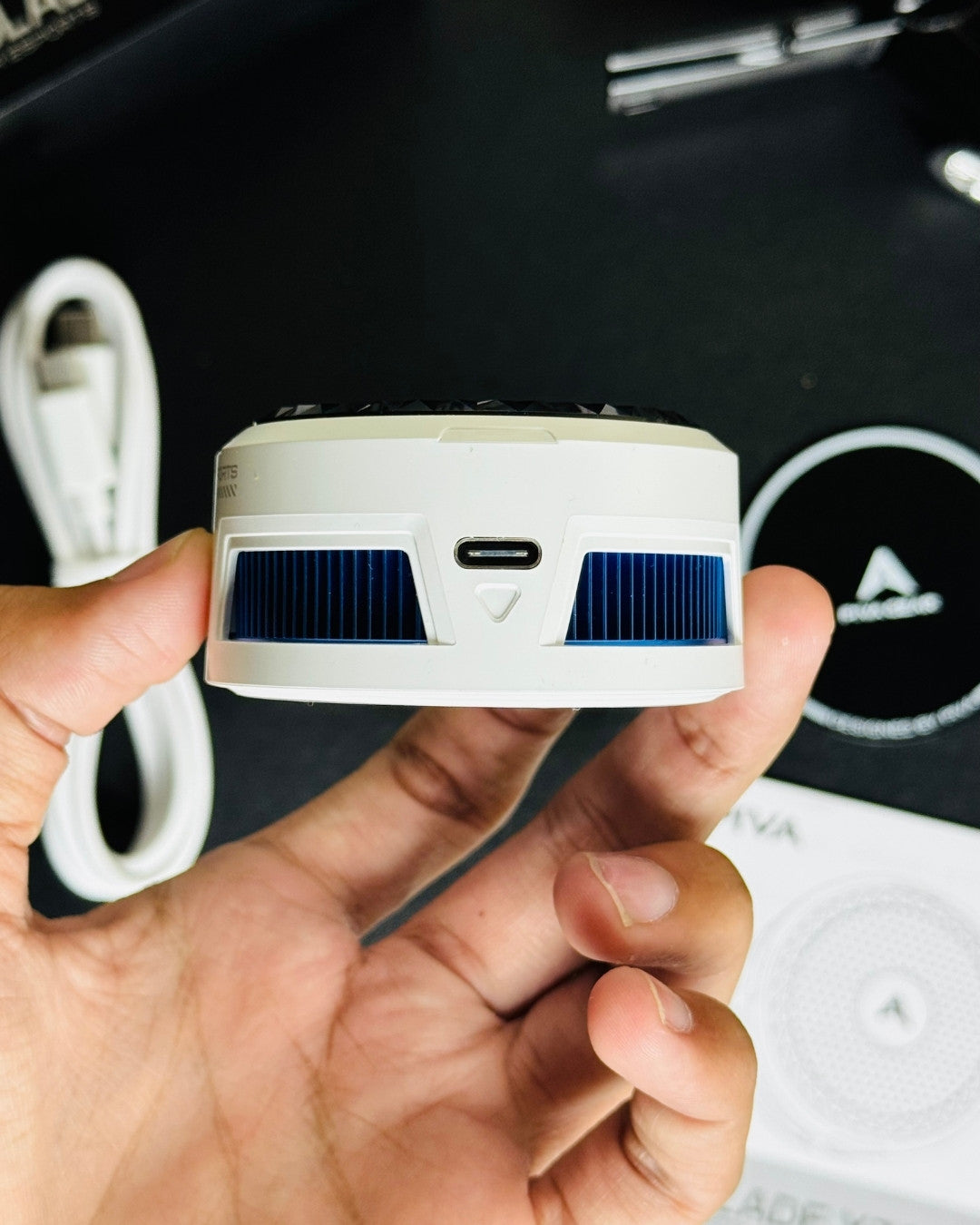 a hand holding of Piva X30 Mobile Cooling Fan and showing a charging port. picture by techbabastore.pk