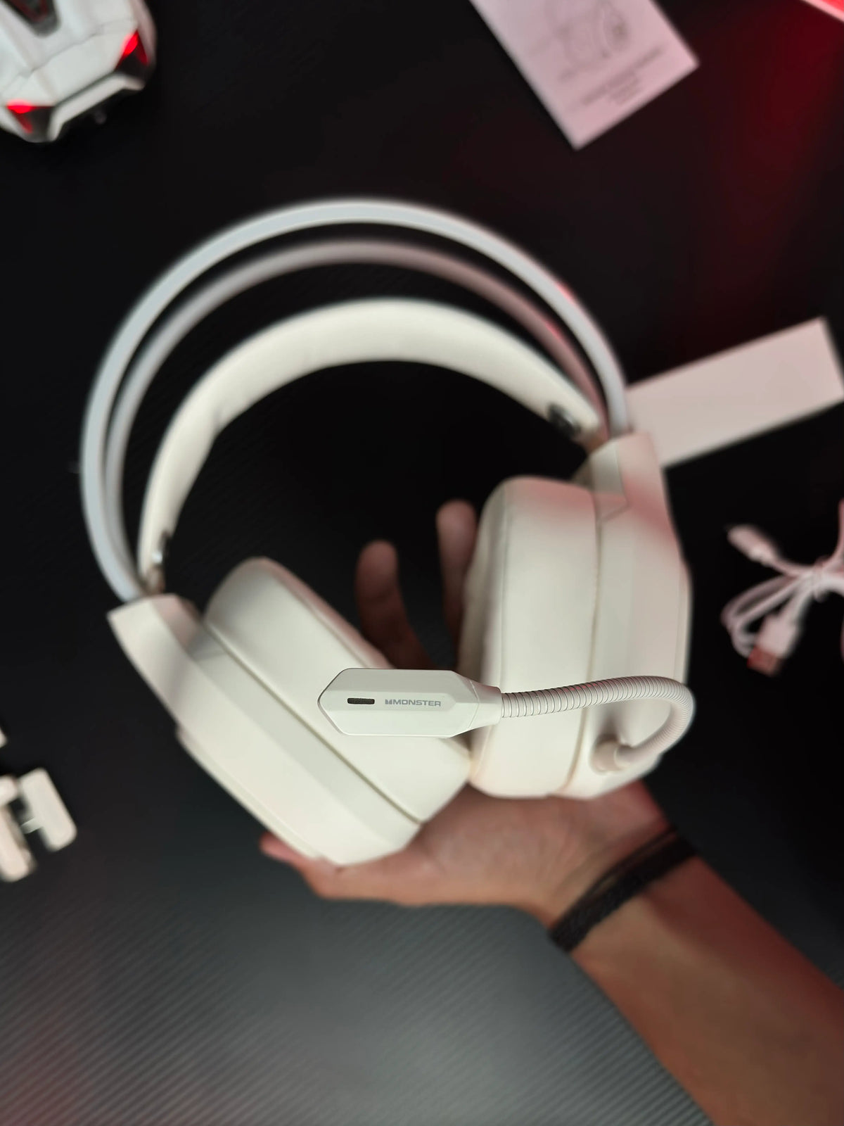 A hand holding Monster_Maxstar_MQH09_Wireless_Gaming_Headphone_50mm_Driver_Bluetooth_5.4_IPX5_Best_PUBG_Headset_Pakistan which has showing  audio connector. picture by TechBabaStore.pk