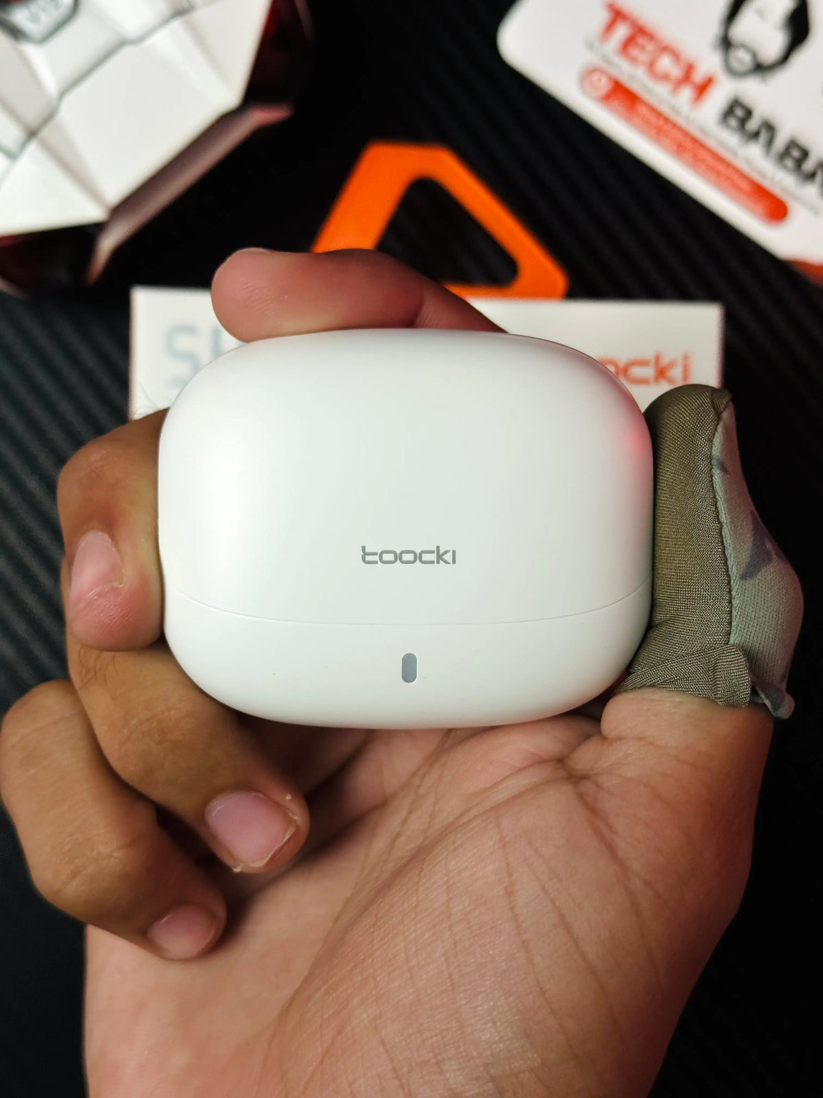 A hand holding Tocki Zero Delay Gaming Earbuds  charging case_picture By TechBabaStore.pk