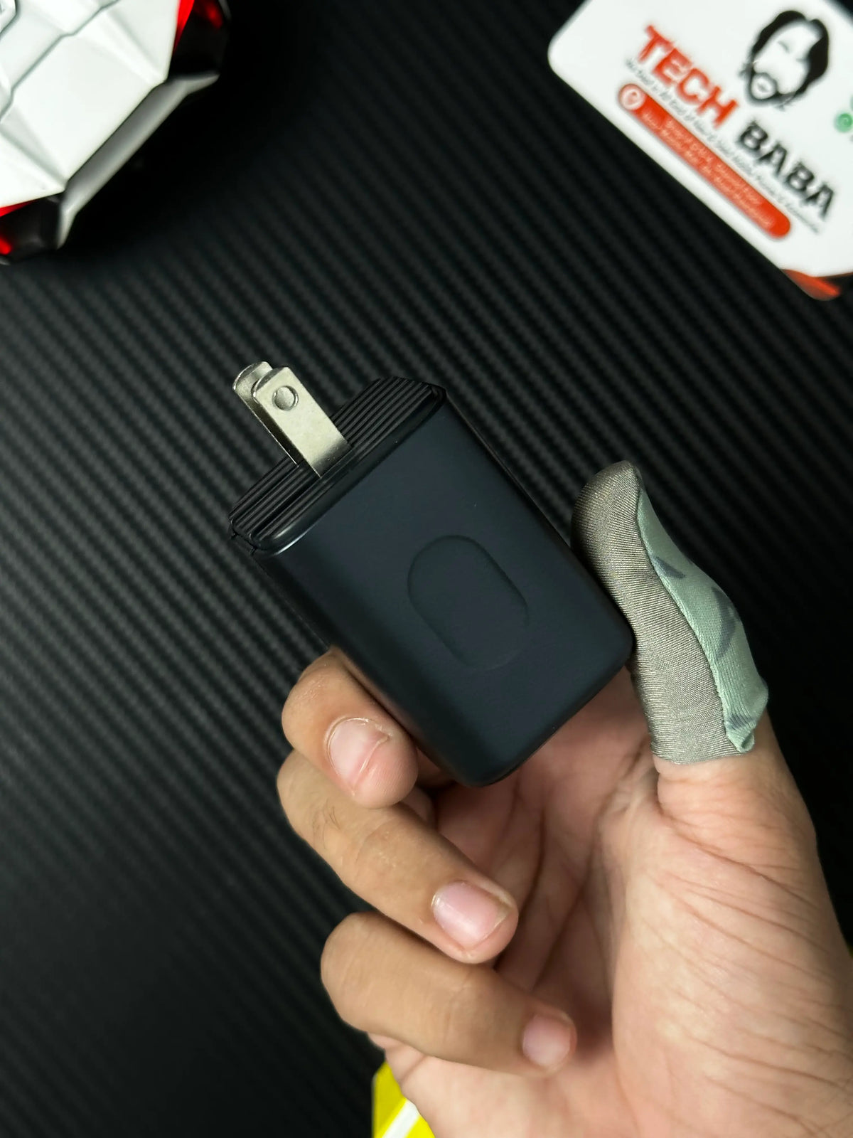 A hand holding Baseus_PicoGo_AE11_67W_GaN_Fast_Charger_2C_U_Dual_USB-C_USB-A_PD3.0_QC4.0_PPS_which has showing  closeup view of connector .picture by TechBabaStore.pk