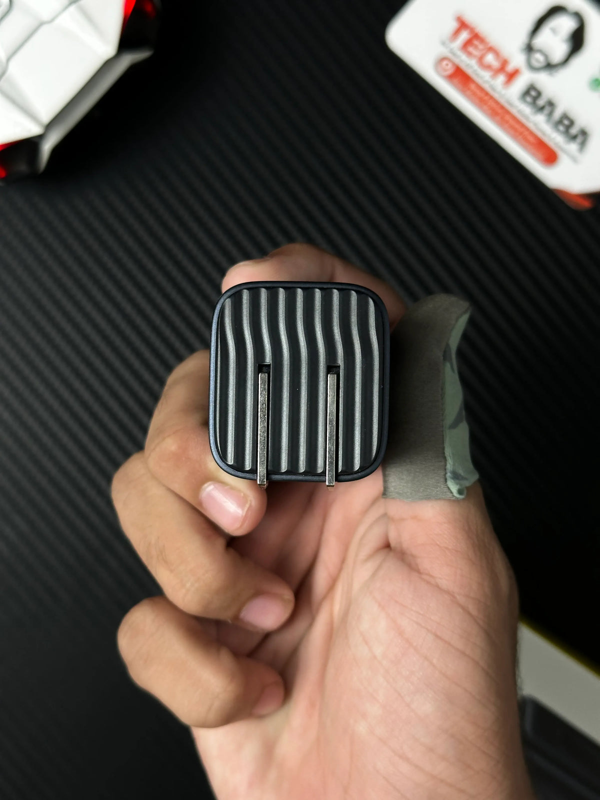 A hand holding Baseus_PicoGo_AE11_67W_GaN_Fast_Charger_2C_U_Dual_USB-C_USB-A_PD3.0_QC4.0_PPS which has showing connector.picture by TechBabaSore.pk