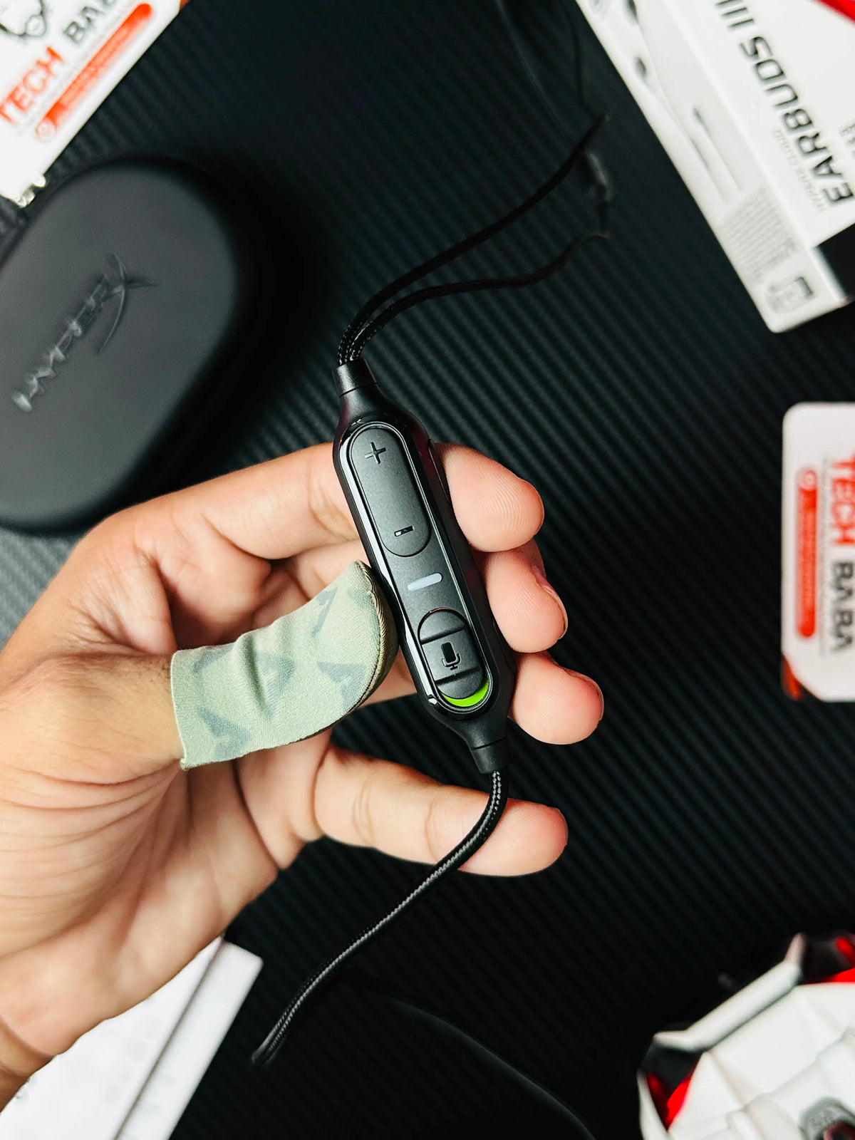 A hand holding control modeul and microphone of HyperX Cloud Earbuds III S USB-C Gaming Earbuds -piture by TechBabaStore.pk