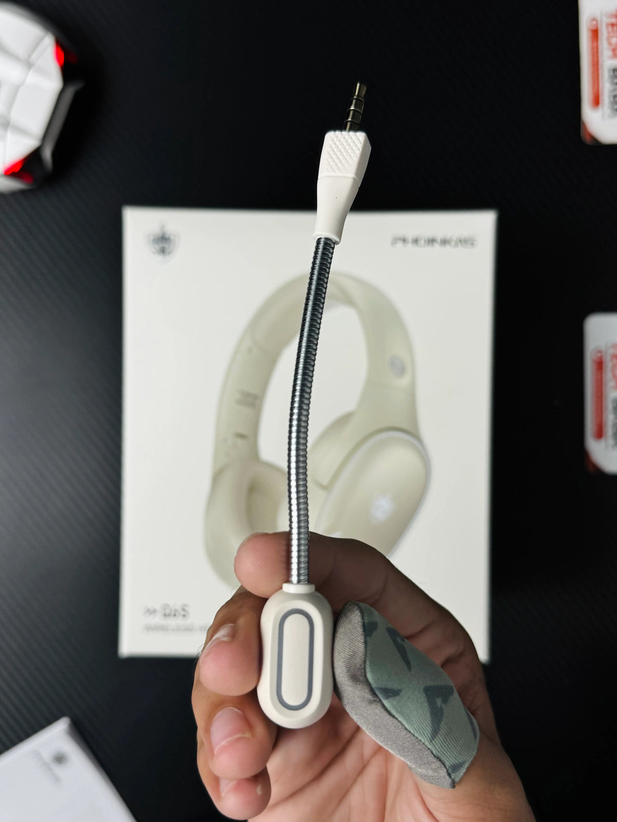 A hand holding Phoinikas Q6S Wireless Gaming Headset — Bluetooth 5.3, Detachable Mic, 30Hrs Battery | Best PUBG Headset Pakistan which has showing deatachable mic.picture byTechBabaStore.pk 
