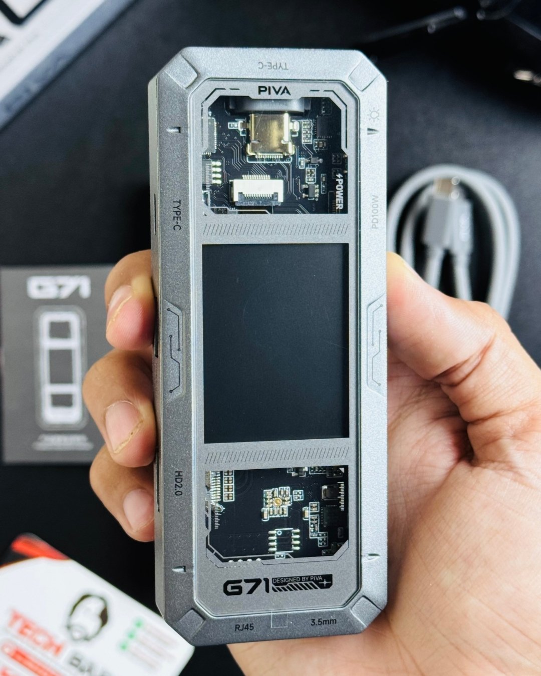 a hand holding PIVA_G71_7-in-1_Gaming_Splitter_Docking_Station showing front side view_ picture by TechBabastore.pk