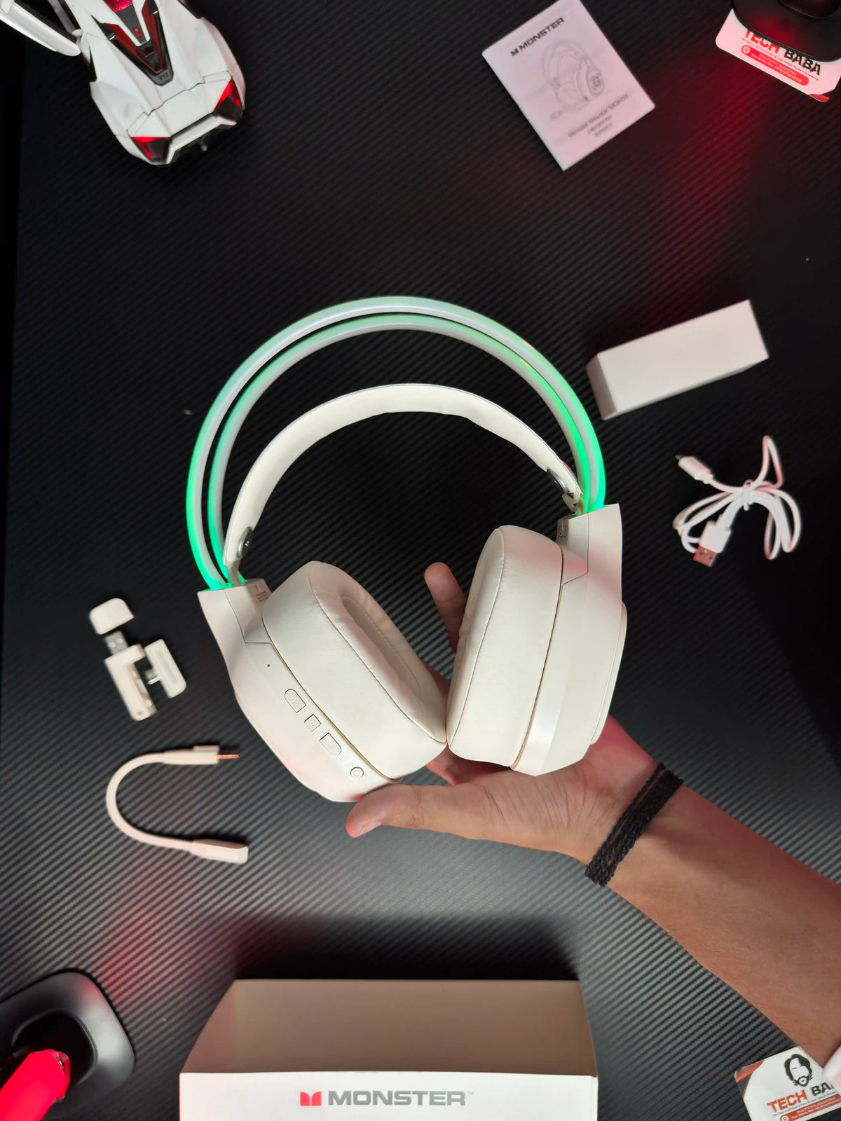 A hand holding Monster_Maxstar_MQH09_Wireless_Gaming_Headphone_50mm_Driver_Bluetooth_5.4_IPX5_Best_PUBG_Headset_Pakistan_which has showing front view of headset. picture by TechBabaStore.pk