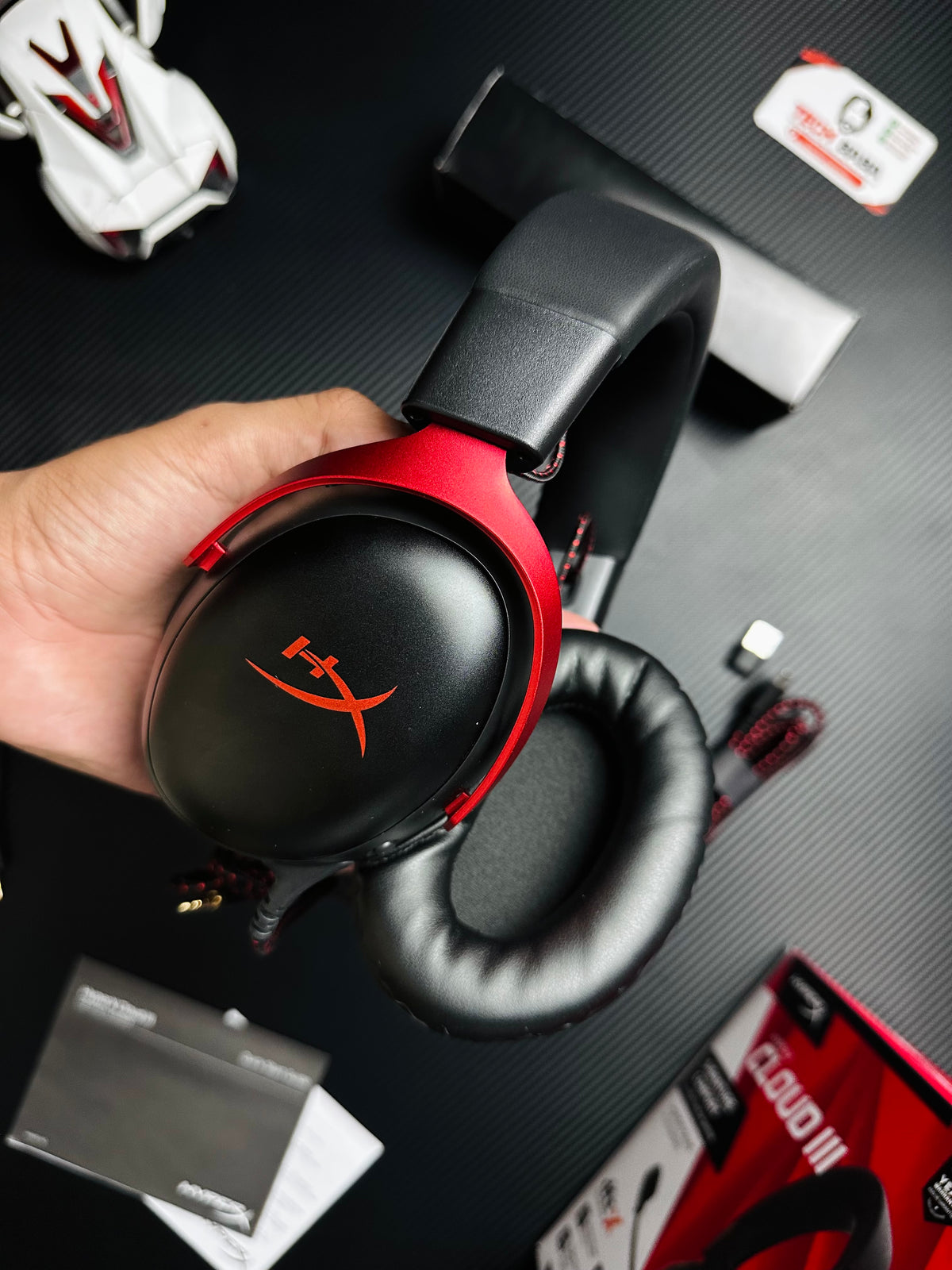 A hand holding HyperX Cloud III Gaming Headset for PUBG Mobile  which has showing side view.picture by TechBabaStore.pk
