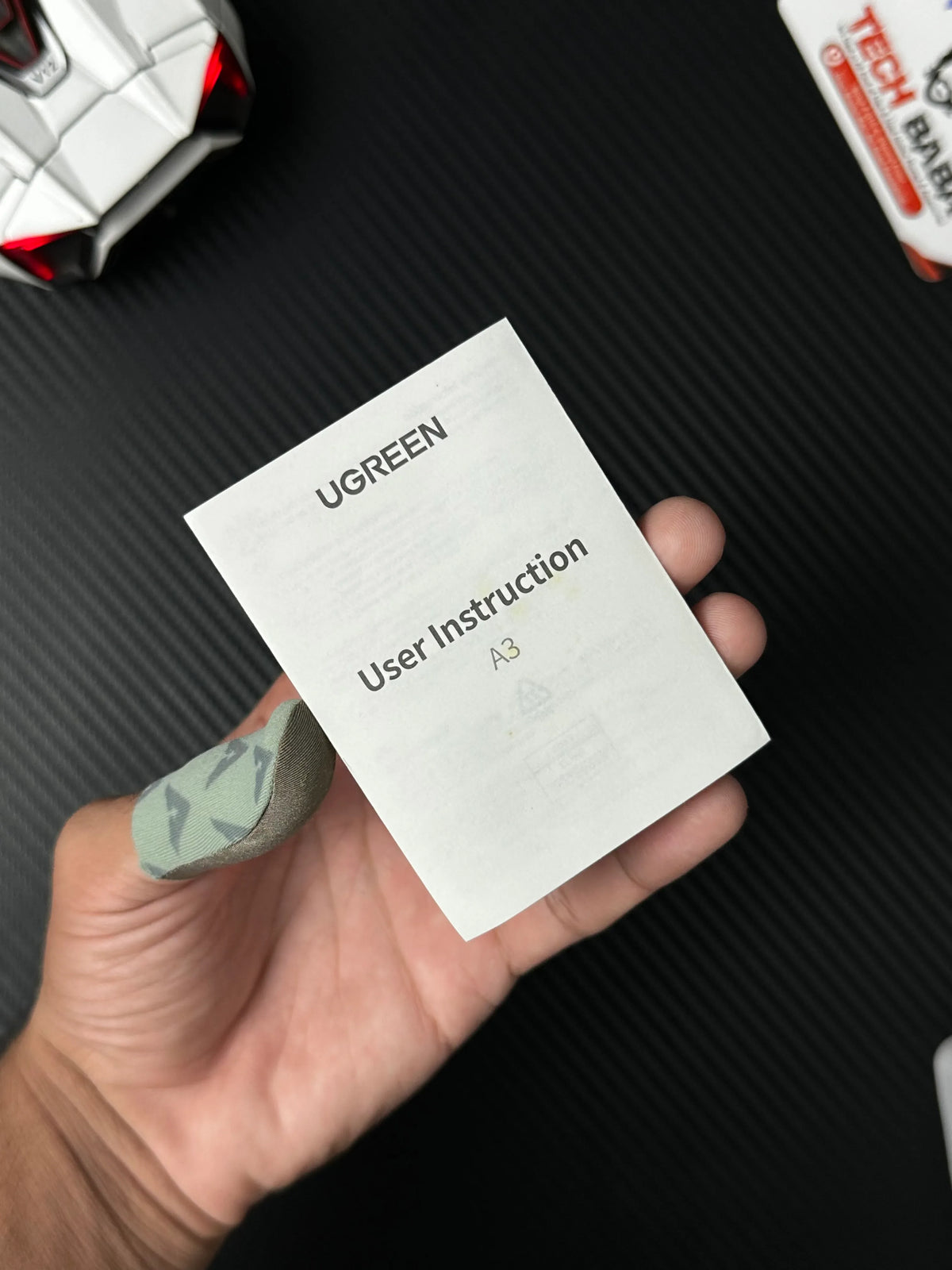 A hand holdingUGREEN 25837 USB-C to 3.5mm Audio Adapter Pakistan which has showing user instruction