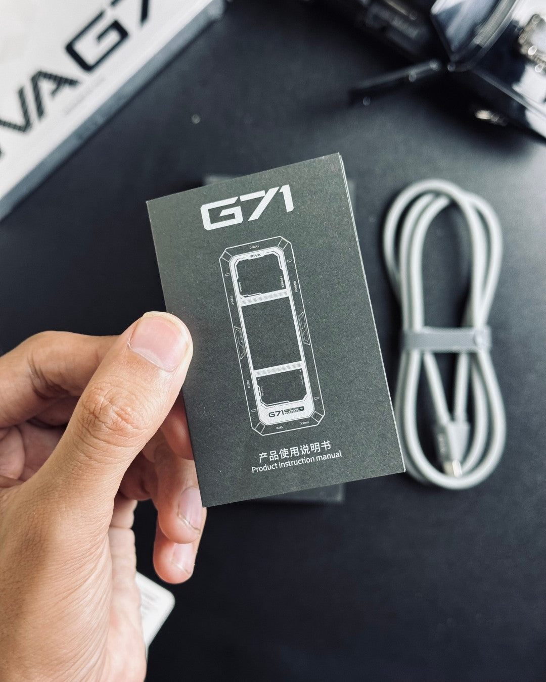 a hand holding user manual of PIVA_G71_7-in-1_Gaming_Splitter_Docking_Station
picture by TechBabastore.pk 