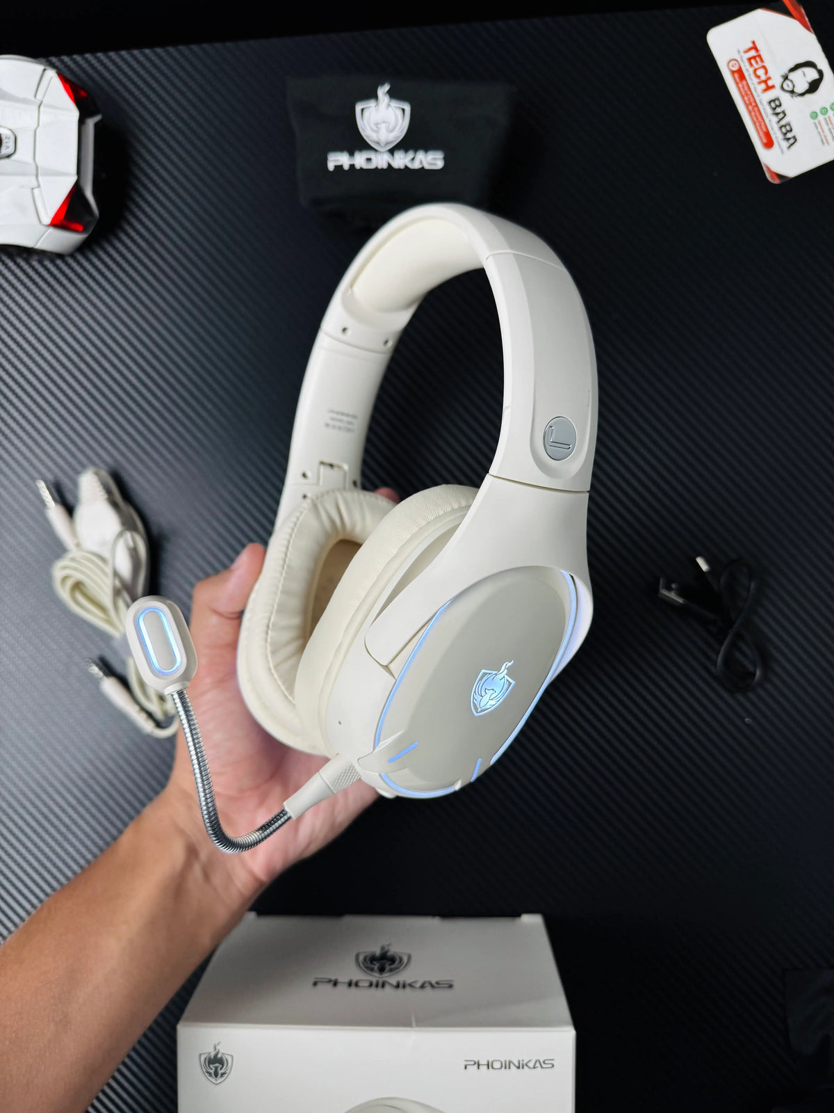 A hand holding white Phoinikas Q6S Wireless Gaming Headset — Bluetooth 5.3, Detachable Mic, 30Hrs Battery | Best PUBG Headset Pakistan which has showing with on lights